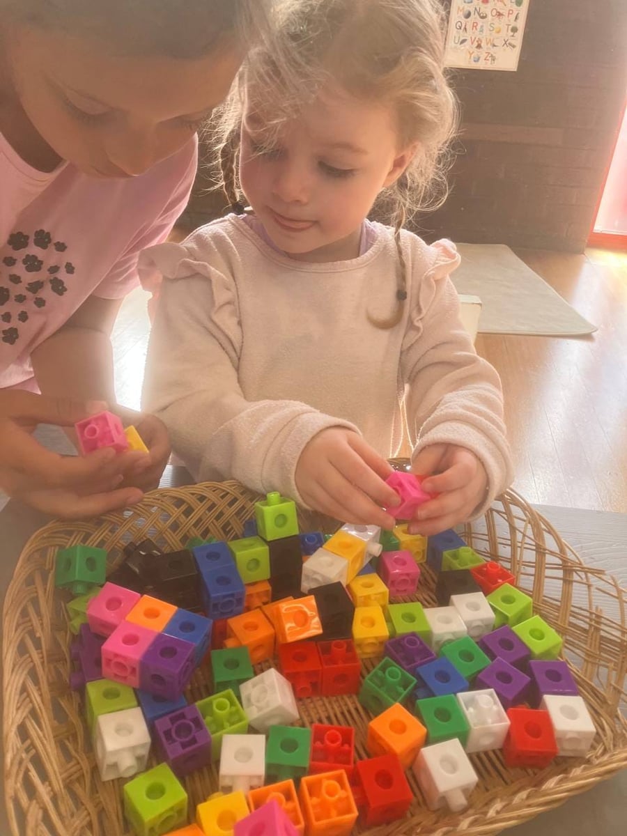 Girls playing with snap cubes at ME Montessori Nursery — fine motor and maths concepts