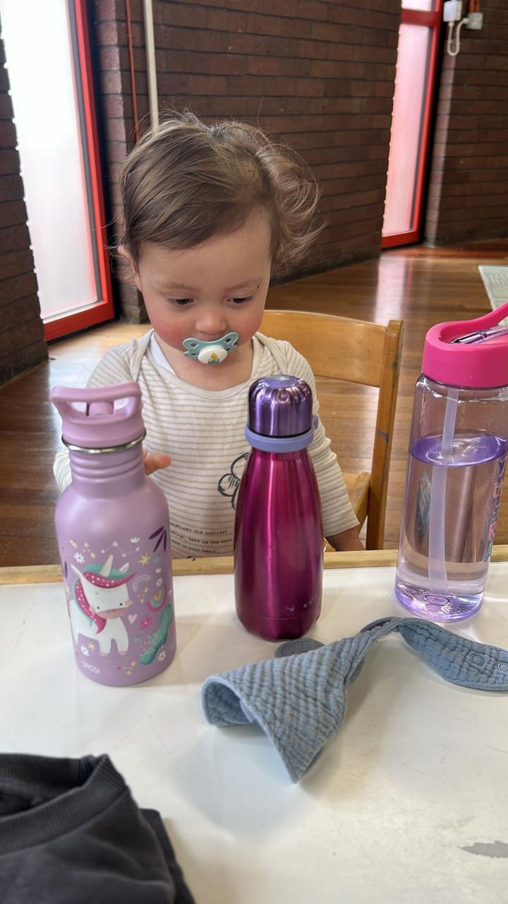 Infant exploring baby bottles at ME Montessori Nursery Aylesbury — heuristic play