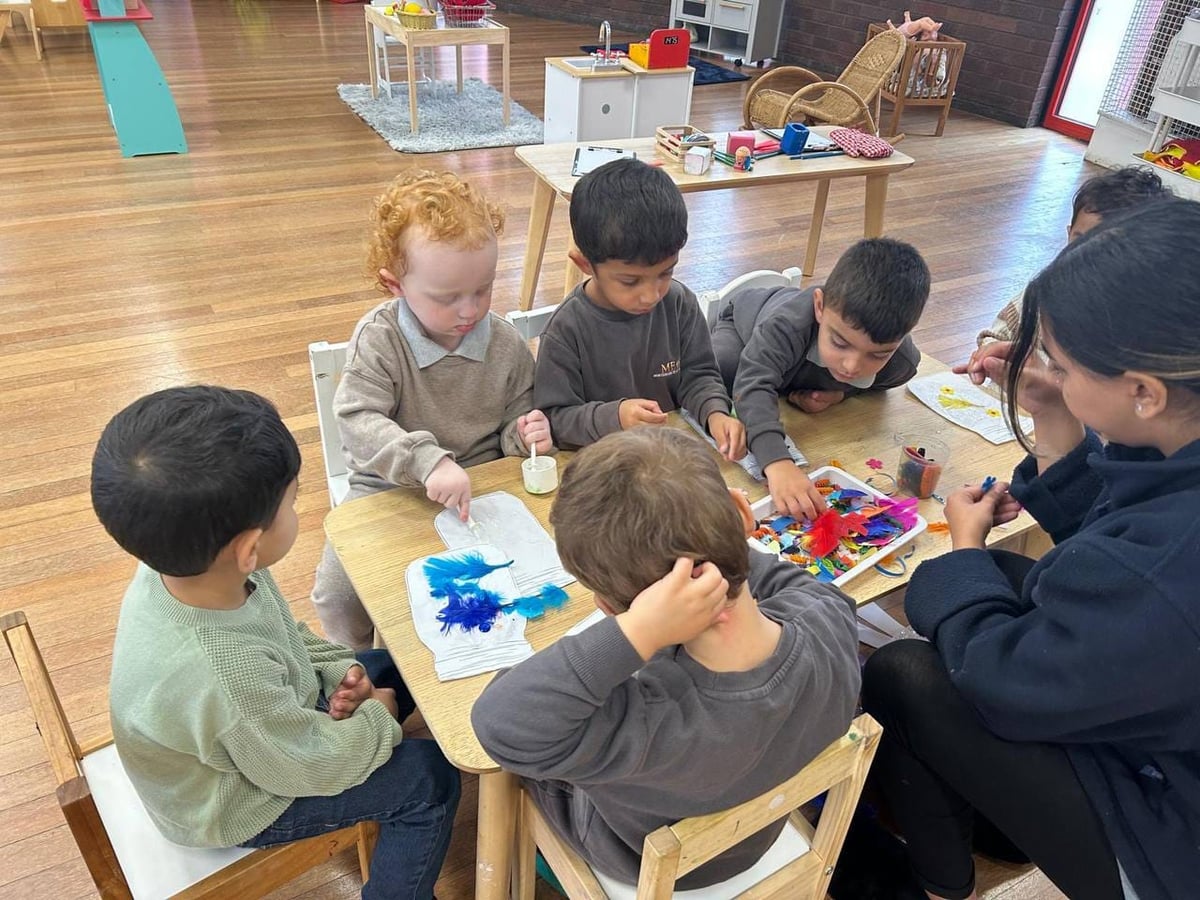 Preschool children making a feather collage at ME Montessori Nursery Aylesbury