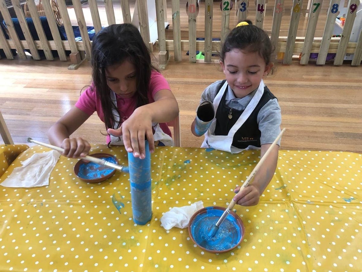 Girls painting with tubes at ME Montessori Nursery Aylesbury — process art and creativity