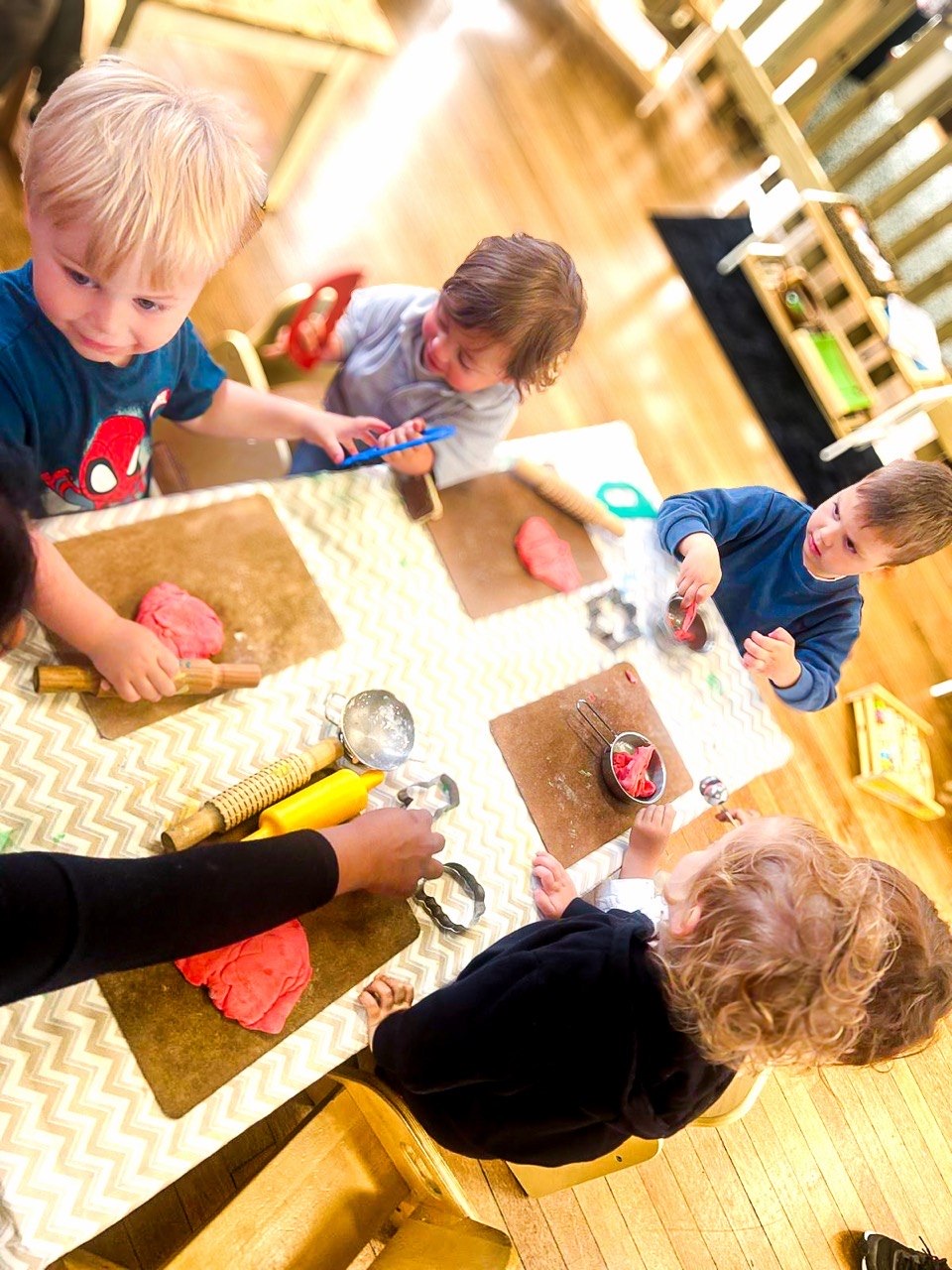 Children exploring playdough together at a child-sized table at ME Montessori Nursery in Aylesbury